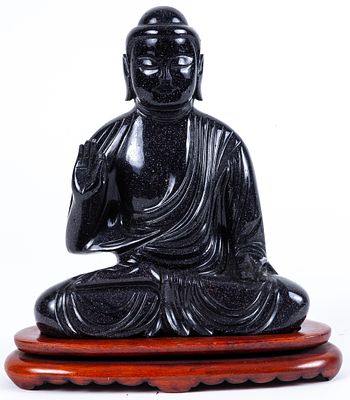 A Chinese black aventurine carved Buddha on a wooden base 19 x 6 x 16 cm 100 - 200 €