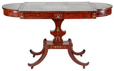 An English gilt brass inlaid mahogany writing table with a leather-lined top, and sabre legs. 