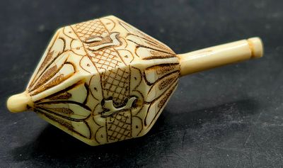 אוסטריה - סביבון חנוכה משנות ה20 מגולף מעצם בקר, בעיצוב קובייתי־מחומש, קל משקל ובעל עיטורים 