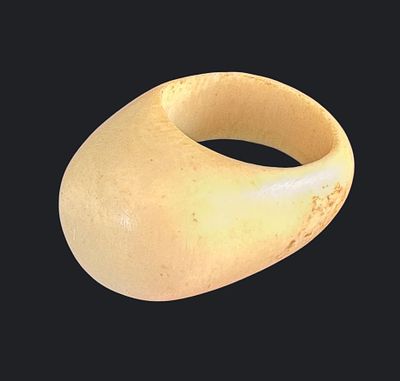 טבעת עבה מחומר אורגני בגוון קרם, בעבודת יד. בעלת צורה אליפטית ועיבוד חלק עם סימני גיל טבעיים. 