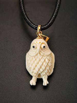 Hand-carved owl pendant crafted from a fine organic material, featuring intricate feather 