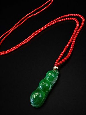 Impressive Jade Pendant on a Delicate Red Coral Bead Necklace A refined necklace composed of 