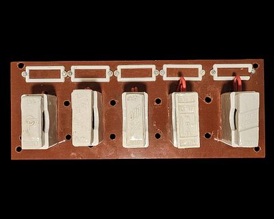 לוח בקליט עם חמישה מבודדי קרמיקה נשלפים שמסומנים בשמות של חברות ישראליות היסטוריות שכבר אינן 