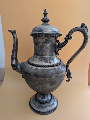 פריט פיוטר (Pewter) 
או מתכת מצופה כסף (silver plate) 
הידית המפוסלת בסגנון רוקוקו/בארוק 
