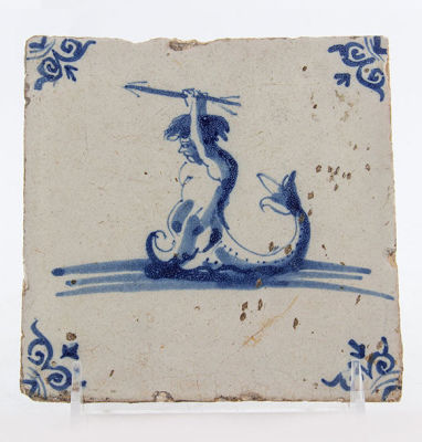 אריח דלפט מצויר ומזוגג כחול לבן המתאר סצינה מיתולוגית, תחילת המאה ה-17, הולנד. מידות: 13X13 ס"מ 