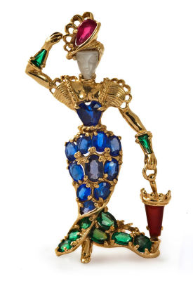 סיכת זהב 14 קרט ואבנים יקרות, כנראה שנות ה-1940. מעוצב כדמות נשית עם מטריה. השמלה משובצת ספירים 