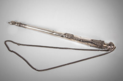 יד לספר תורה מכסף וכסף פיליגרן, בצלאל, 1920 בקירוב. משובצת בענברים (?), עם שרשרת כסף. חתומה 