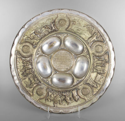 צלחת לסדר פסח מפליז מוכסף, בעיצוב זאב רבן, בצלאל, שנות ה-1920. מעוטרת בסצינות מיציאת מצרים. 