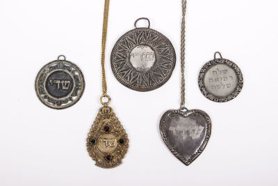 חמישה תליוני קמעות מכסף. כולל:1. תליון קמע מכסף בצורת לב, משה רובין, לונדון, 1926-31גובה: 5.6 