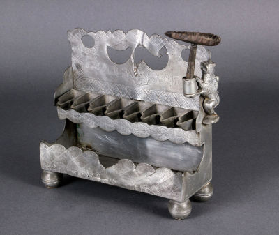 חנוכיית פיוטר נדירה, גרמניה, 1757. הלוח האחורי גזור עם ארבעה פתחים, מוחתם וחרוט כיתוב עברי 