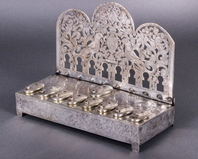 חנוכיית כסף נדירה ונאה מאוד, תוניסיה, 1856-1905. הלוח האחורי גזור וחקוק בשתי ציפורים משני צידי 