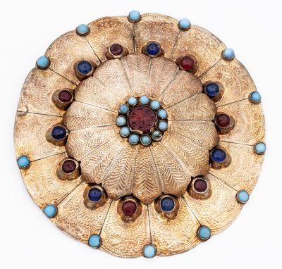 עיטור חזה מכסף מוזהב "גולייקה", שבט היומוט, המאה ה-19. תיאור: מעוצב כפרח עם עבודת פטיש וחריטה 