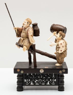 קבוצה פיסולית משנהב מגולף וצבוע בדמות זוג דייגים על רפסודה, יפן, 1900 בקירוב. תיאור: דמויות 