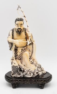 אוקימונו משנהב מגולף וצבוע בדמות דייג השולה דג, יפן, תחילת המאה ה-20. תיאור: מוצב על בסיס מוגבה. 