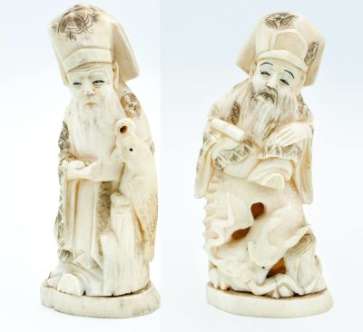 שני פסלוני אוקימנו משנהב בדמות קוסמים, יפן, תחילת המאה ה-20. תיאור: חותמות (בתחתית). 
גובה: 19.5 