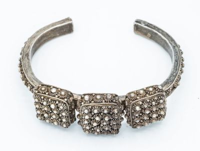 צמיד כסף נאה, תימן, המאה ה-19. תיאור: במרכז שלושה אלמנטים מרובעים משובצים בחרוזי כסף זעירים 