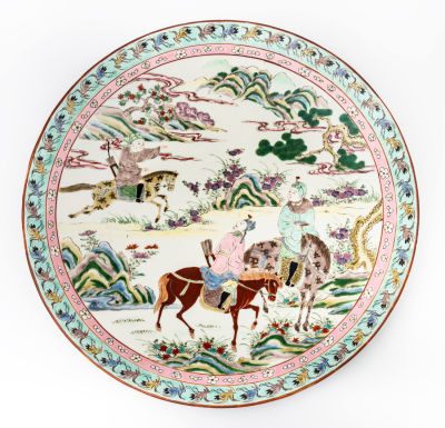 צלחת חרסינה משובחת Famille Rose, סין, המאה ה-19-18. תיאור: מעטורת בסצנת ציד מפורטת ותחומה בשני 