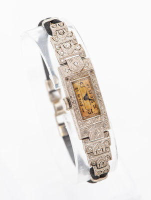 שעון אר-דקו מקסים לאישה מפלטינה ויהלומים. פני השעון ושוליו מעוטרים במוטיב אר-דקו גיאומטרי המשובץ 