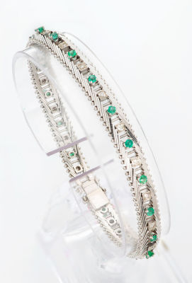 צמיד זהב לבן 18 קראט משובץ יהלומים ואמרלדים. פס גמיש המורכב מאלמנטים אלכסוניים המחוברים בינהם 
