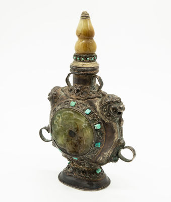 בקבוק שעוות דבורים טיבטי מסגסוגת משובץ ג'ייד מגולף וטורקיז. מוצב על בסיס סגלגל ומעליו גוף מעגלי 