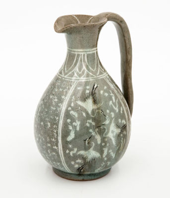 קנקן סלדון מזוגג, קוריאה, 1600 בקירוב. גוף פקעתי מעוטר בלוחות המתארים עגורים בתעופה בעבודת שיבוץ 