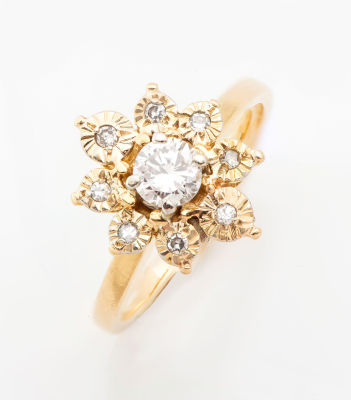 טבעת מזהב 18 קראט ויהלומים. כתר הטבעת מעוצב כפרח שבמרכזו יהלום איכותי (0.3 קראט בקירוב)בחיתוך 