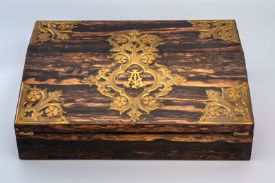 מכתבת מסע איכותית מעץ אגוז, אנגליה, 1880 בקירוב. החלק החיצוני של המכתבה מעוטר בפינותיו ומרכזו 