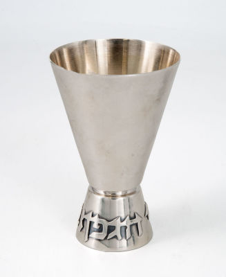 גביע קידוש מכסף סטרלינג על ידי לודוויג וולפרט (Ludwig Wolpert). הגביע בעל מבנה קונוס כאשר על 