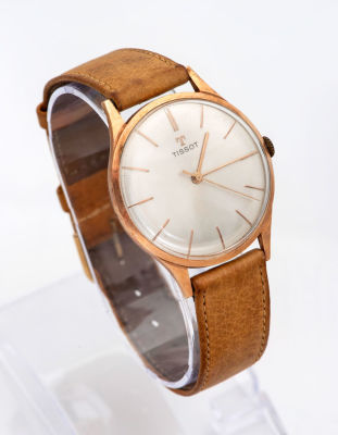 שעון יד TISSOT מזהב. מנגנון: מכני 
גוף מזהב 
לוח בגוון קרם מוברש עם סימני קוים במקום ספרות. 