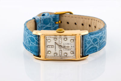 A 14K Gold Lady's Wrist Watch by Longines. Details The rectangular dial studded with small 