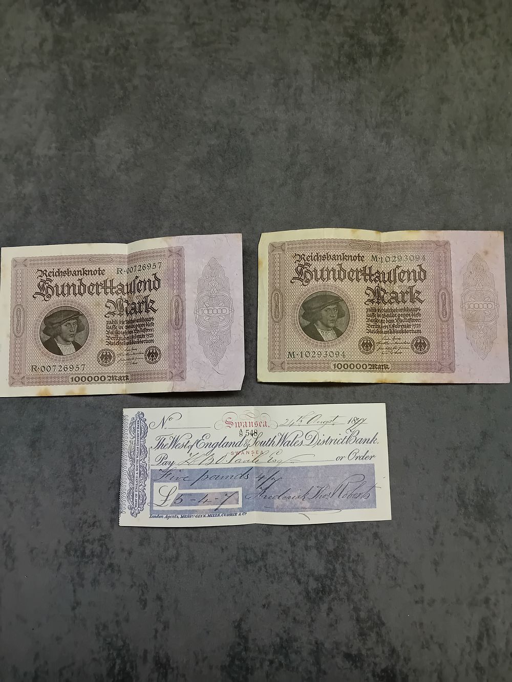 Lot 259: Mixed Lot, 2 x German 100000 Mark bank notes. (R00726957) amd (M10293094) also includes 1899 cheque Swansea.