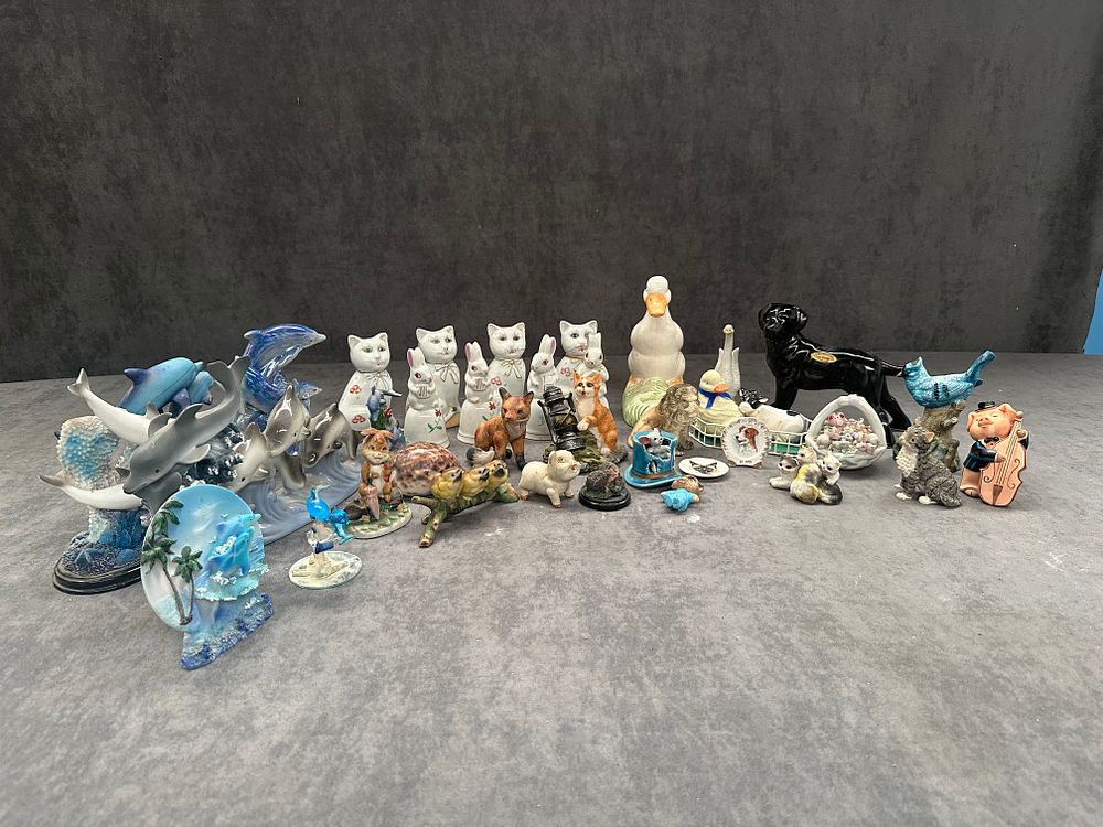 Lot 549: A huge mixed lot of animal related ceramics and animal related items as pictured. This includes a Staffordshire ceramic black Labrador dolphin items, rabbit bells, cats, and many more.
