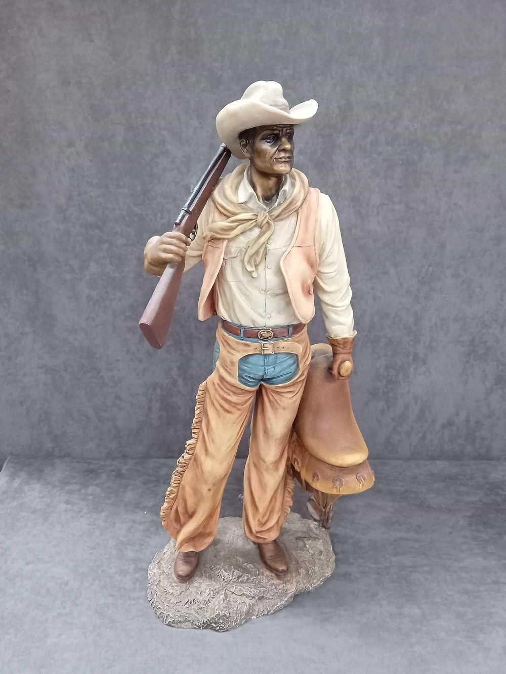Lot 469: The Leonardo Collection Cowboy holding saddle and rifle...