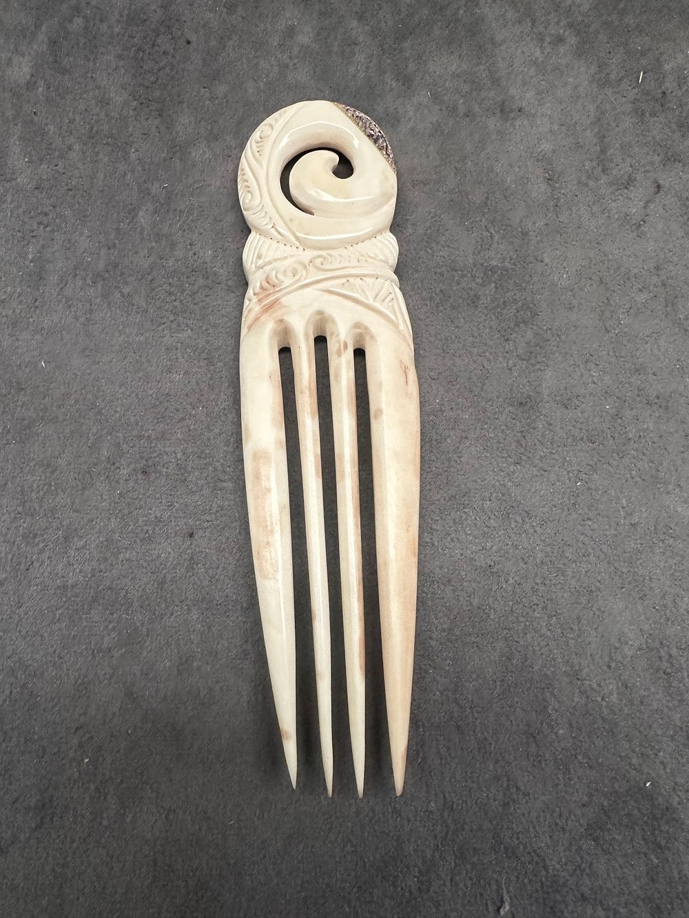Lot 639: A Carved Bone Heru with Koru Motif and Abalone Inlay