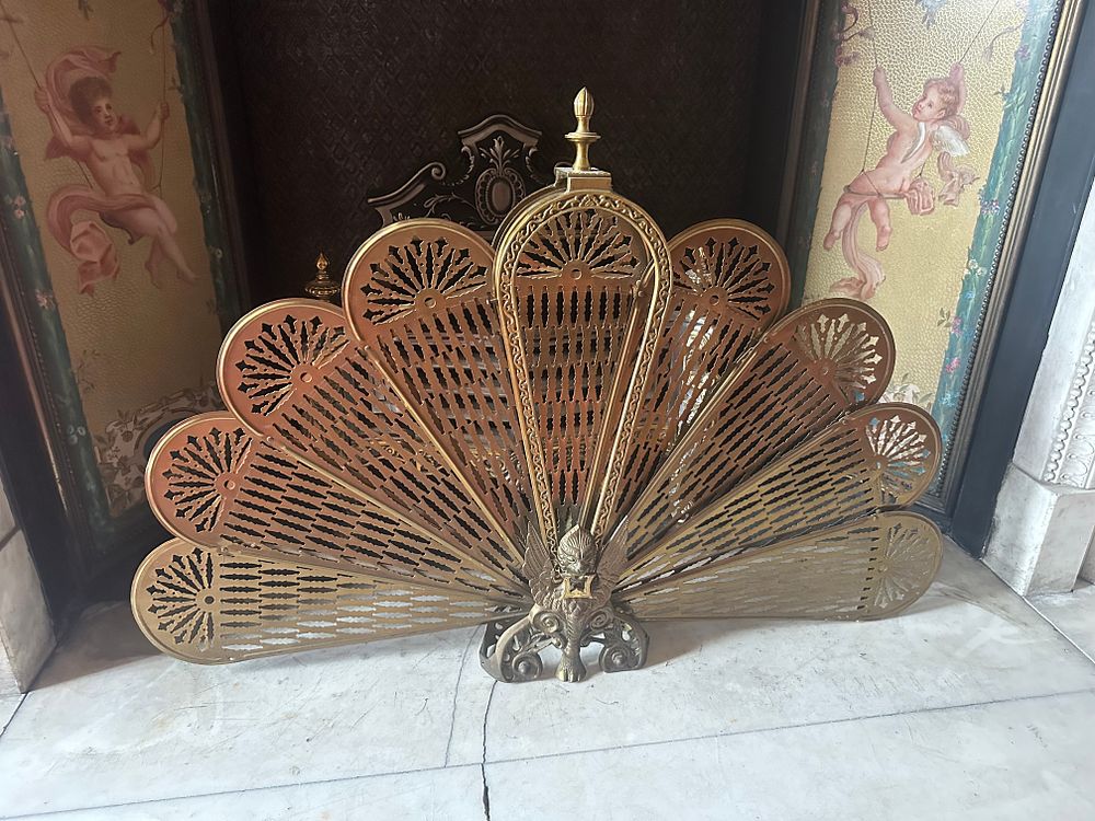 Lot 1027: A Late 19th/Early 20th Century Brass Peacock Style Folding Fan Fire Screen and a Cast Iron Fire Basket