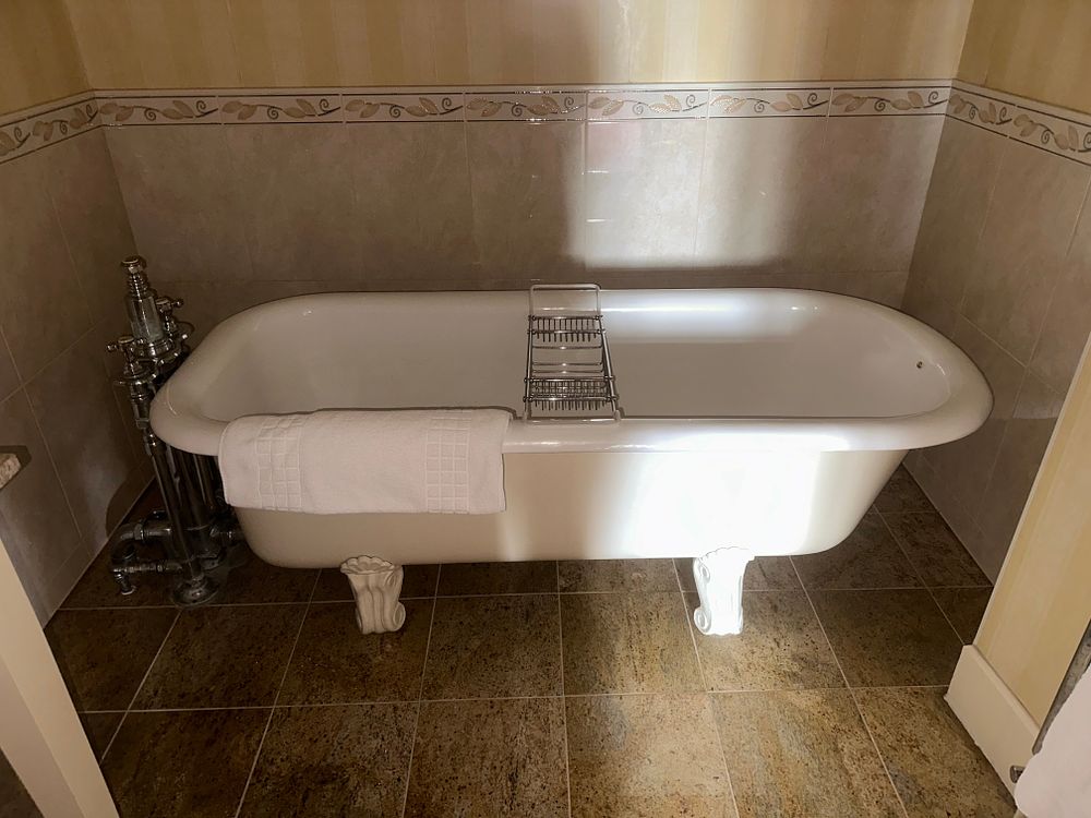 Lot 1040: A Cast Iron Roll-Top Clawfoot Bathtub with Chrome-Plated Fixtures