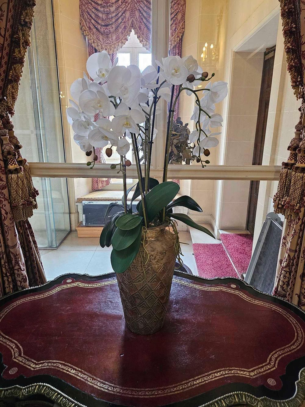 Lot 4: An Artificial Phalaenopsis Orchid Arrangement in a Textured Bronze-Effect Vase