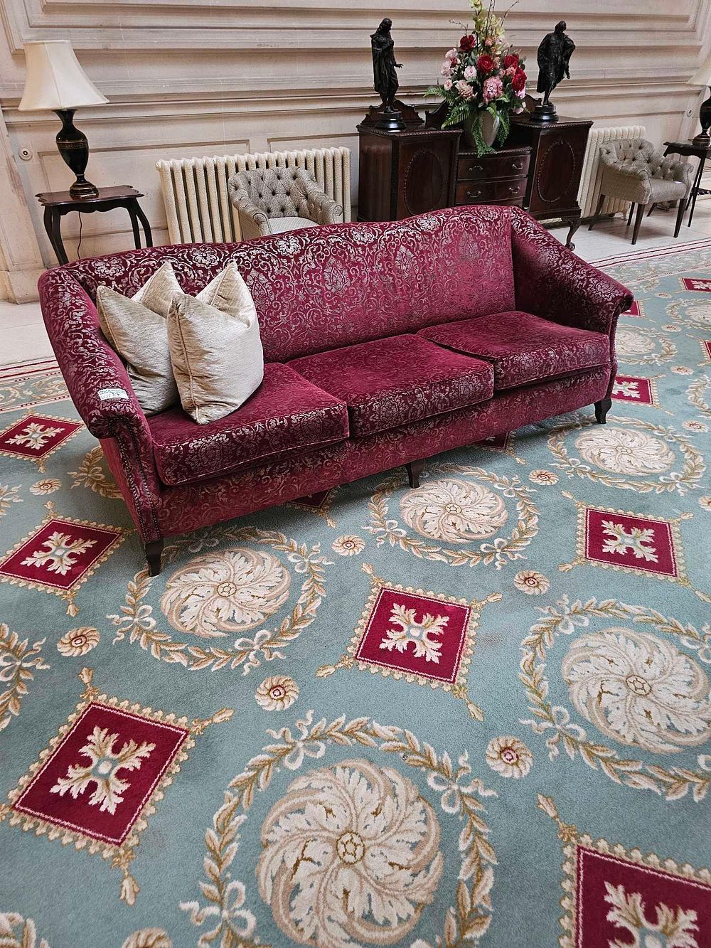 Lot 27: A Georgian-Revival Style Three-Seater Sofa, upholstered in red velvet damask