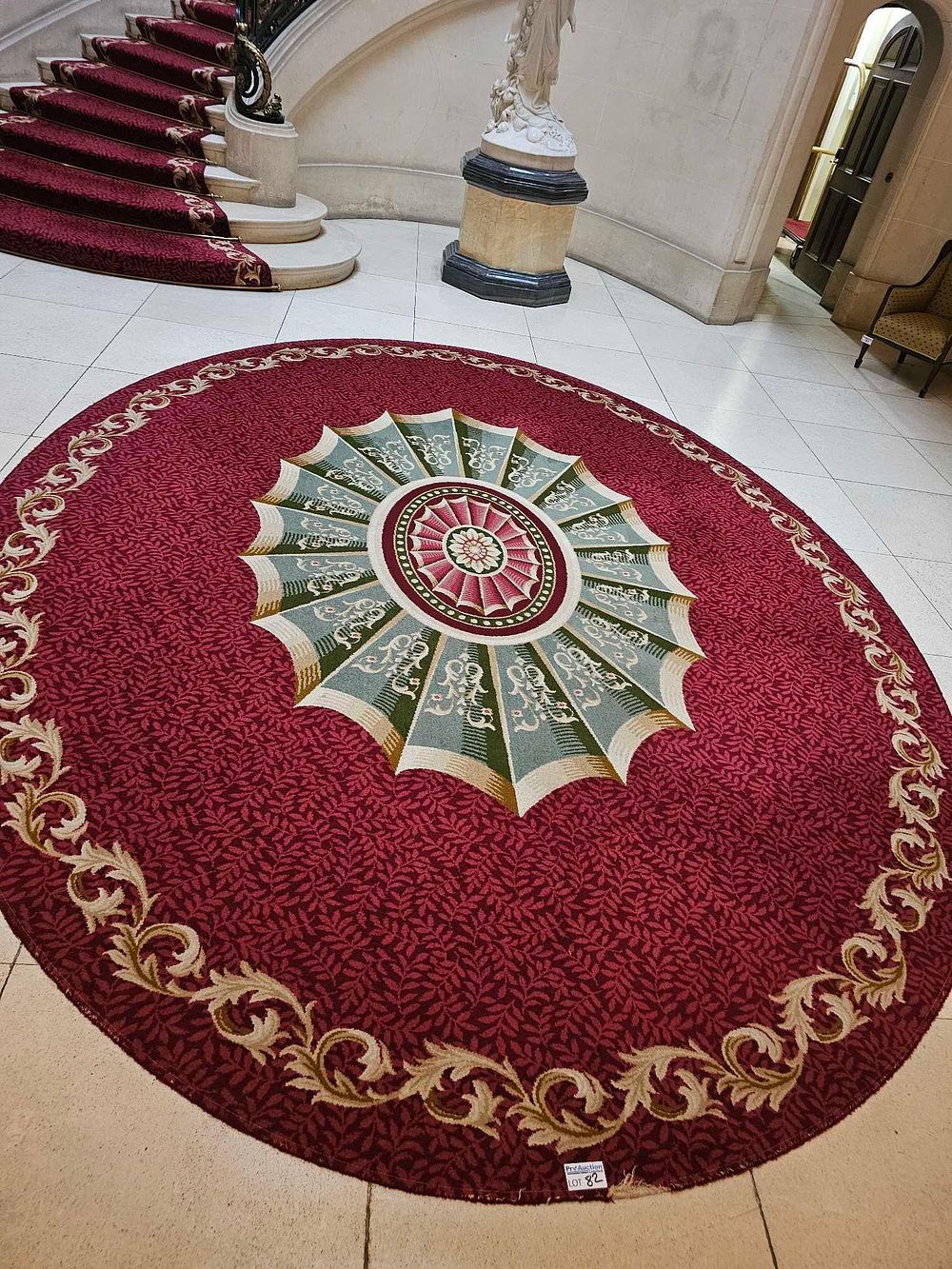 Lot 82: A Large Oval Machine-Woven Traditional Medallion Area Rug, Red Field