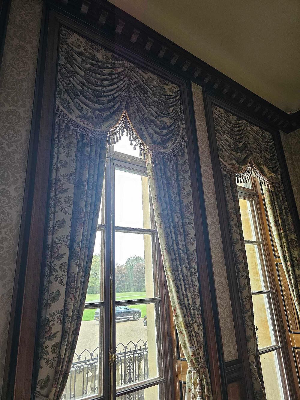 Lot 111: A Pair of Classical Revival Style Botanical Chintz Window Treatments with Swagged Valances and Tassel Tie-backs