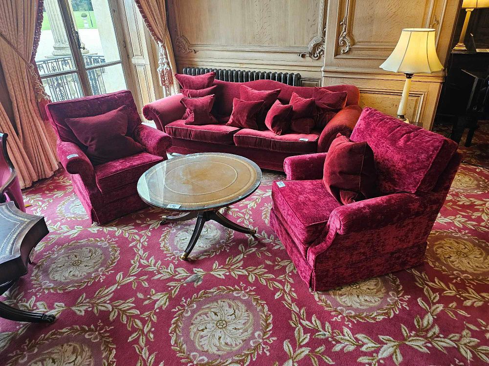 Lot 135: A Traditional Red Crushed Velour Seating Suite and Leather-Inlaid Coffee Table