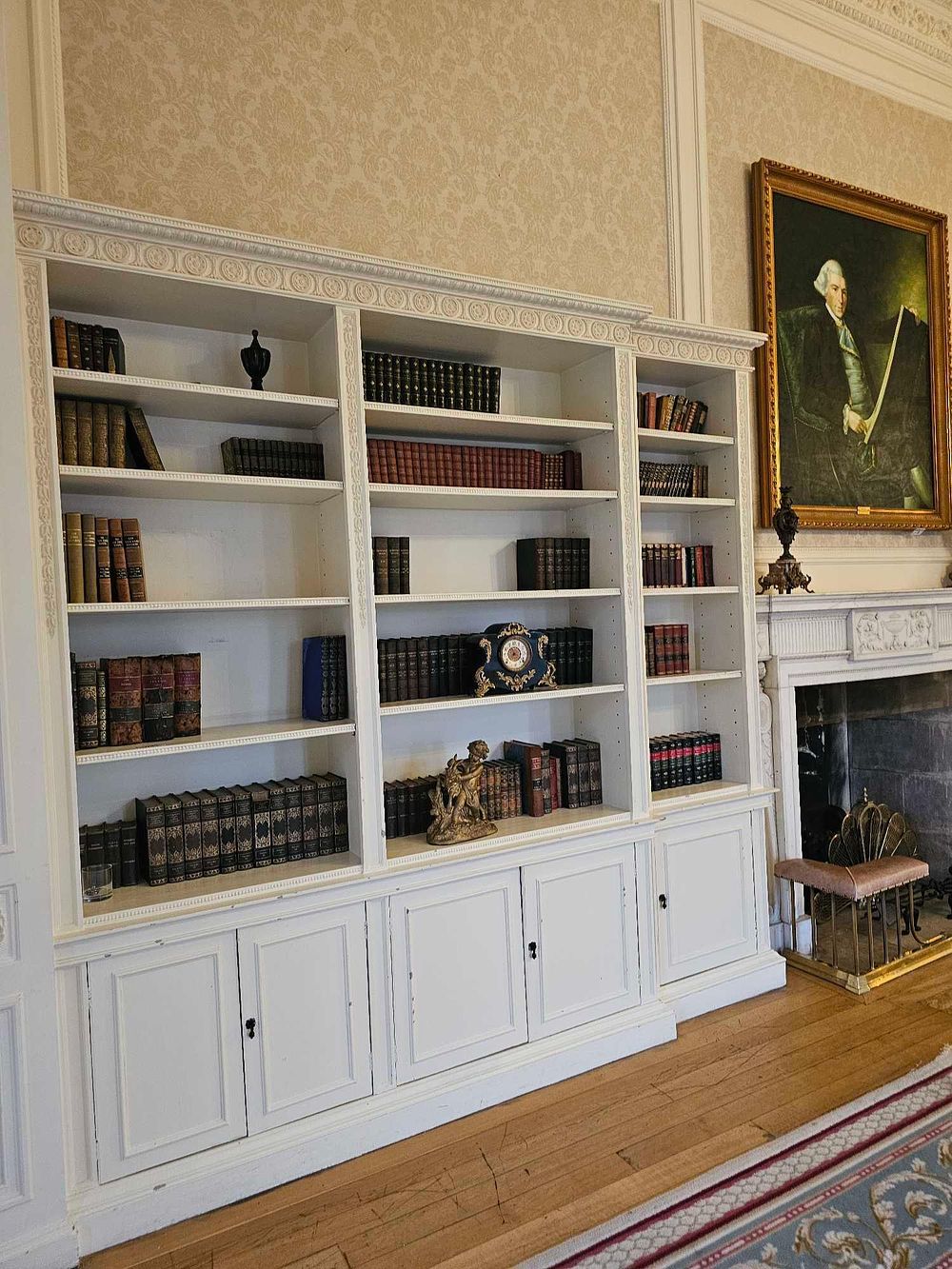 Lot 177: A Large Neoclassical Style Built-In White-Painted Bookcase with Concealed Doorway