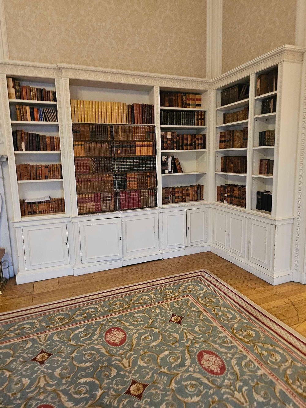 Lot 178: A Large Neoclassical Style Painted Wood Corner Library Bookcase System, with a Collection of 18th and 19th Century Books