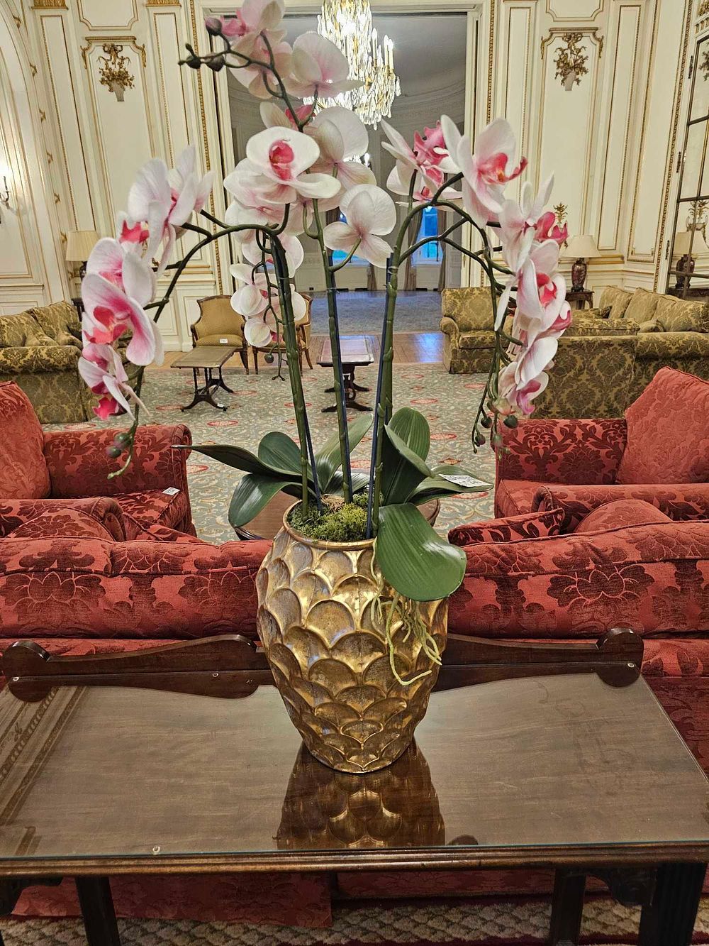 Lot 230: A Large Faux White and Pink Phalaenopsis Orchid Arrangement in a Gold-Toned Urn-Shaped Planter