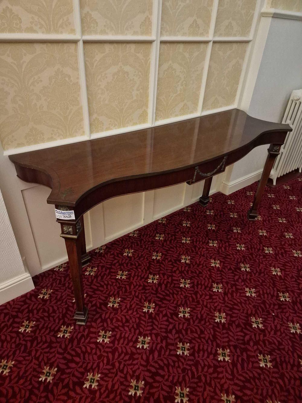 Lot 363: A Neoclassical Style Gilt-Metal Mounted Mahogany Serpentine Console Table
