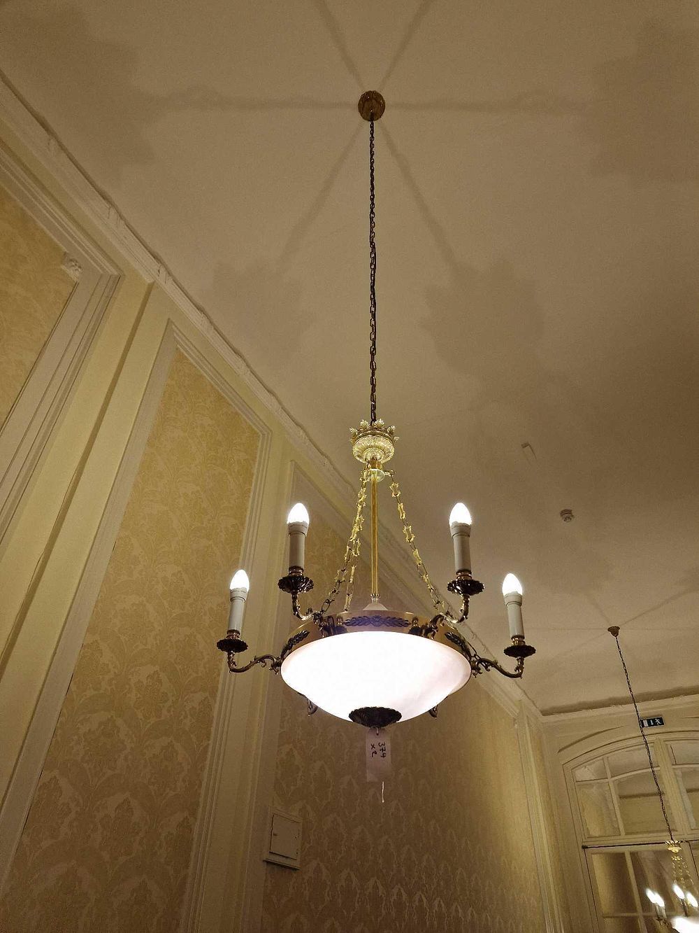 Lot 374: A Six-Arm French Empire Style Brass-Toned Metal and Glass Chandelier