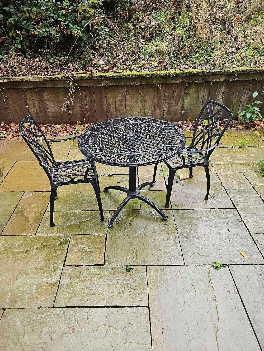 Lot 585: A Three-Piece Dark-Painted Cast Aluminum Outdoor Bistro Set with Openwork Lattice Design