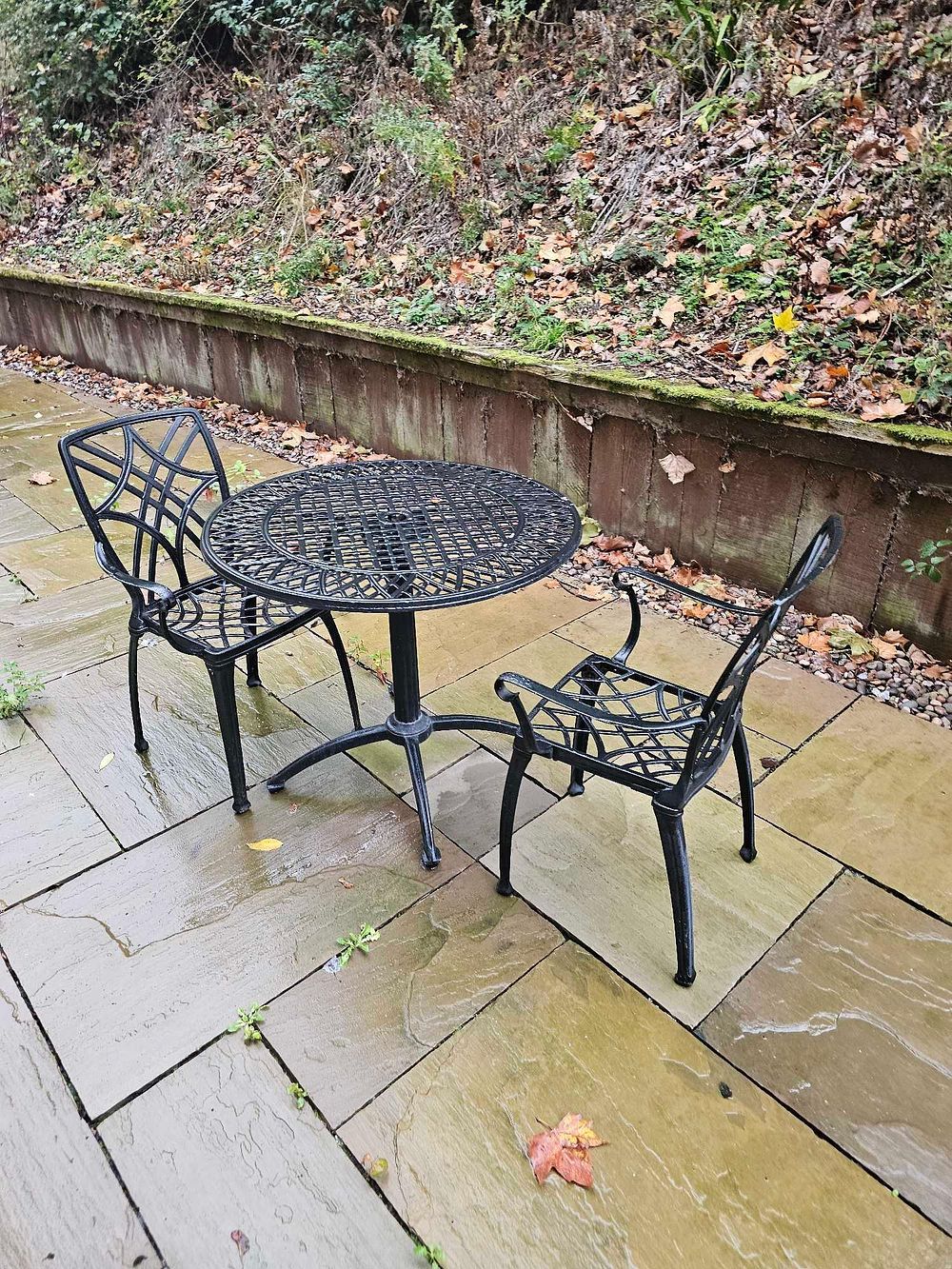 Lot 590: A Three-Piece Black Cast Aluminum Outdoor Bistro Set with Geometric Lattice Design