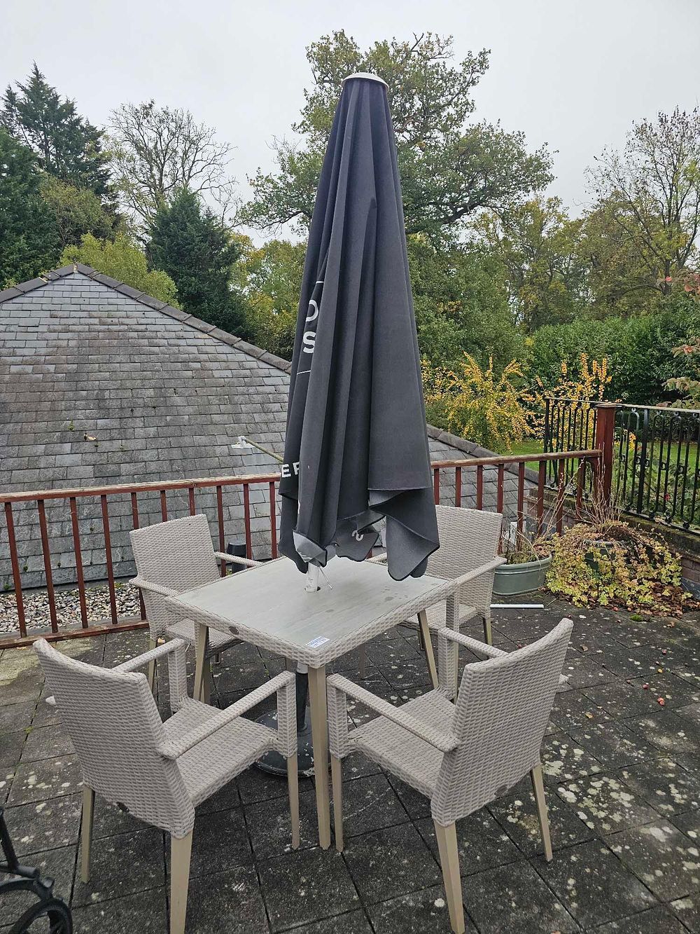 Lot 770: A Modern Outdoor Patio Dining Set comprising a Square Table, a Set of Four Armchairs, and an Umbrella