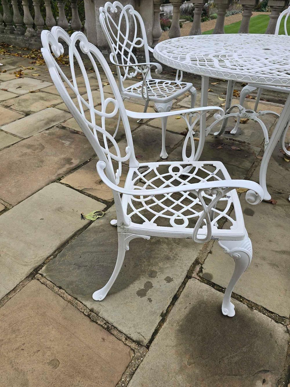 Lot 2104: A Victorian Style White Painted Cast Aluminum Garden Dining Set, comprising a Table and Four 'Heart-Back' Chairs